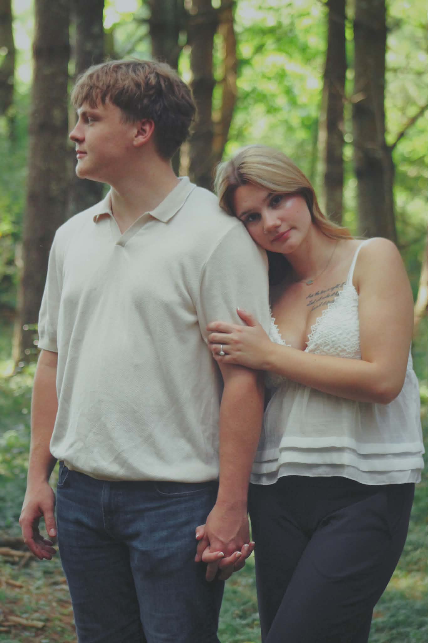 Couple holding hands in a sunlit forest